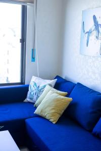 安曼Jubeiha View Apartments的客房内的蓝色沙发上配有枕头