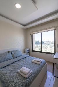 安曼Jubeiha View Apartments的一间卧室配有一张床,上面有两条毛巾