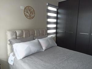 安巴托Lujoso Apartamento Frente al Estadio Bellavista的卧室配有带白色枕头的大床