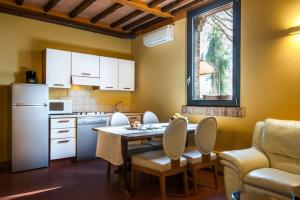 格罗塞托凡托利亚圣洛伦索酒店的厨房配有桌椅和冰箱。