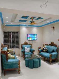 达卡Stunning 1-Bed Apartment in Dhaka close to airport的客厅配有蓝色的椅子和桌子