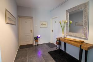 奥西耶克Rooms BAUMAN的走廊上设有镜子,铺有瓷砖地板