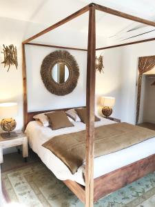 圣保罗-德旺斯Bastide Nomade - Charming B&B的一间卧室配有四柱床和镜子