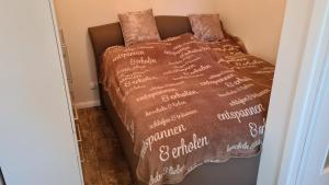 特拉弗明德PEMATRA Ferienwohnung Strandmuschel的棕色棉被床,上面写着