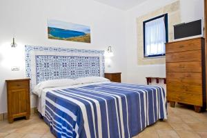 法维尼亚纳米拉马雷公寓式酒店的一间卧室配有一张带蓝白色毯子的床