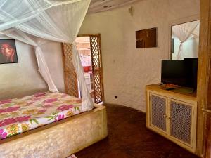 马林迪Peponi Villa Malindi的一间卧室配有一张床和一台平面电视