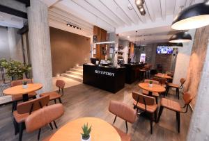 斯科普里亚力山大广场精品酒店的餐厅设有木桌、椅子和柜台