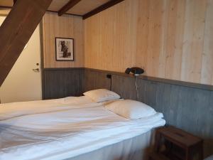 厄勒格伦德Epokgården的木墙客房的一张带两个枕头的床