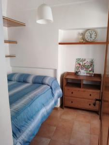 菲乌吉Alloggio Turistico Lidia的一间卧室配有一张床、梳妆台和时钟