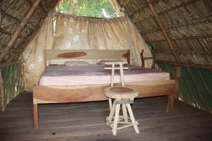 AltagraciaLa Sirenita - Ometepe的一间卧室配有一张床,帐篷内配有凳子