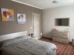 卡斯塔诺兰泽Maison Younesco - Villa indipendente exclusive的一间卧室配有一张床、梳妆台和电视。