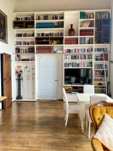 GualdoVILLA ANCORA Tenuta Lonciano的客厅配有桌子、电视和书籍