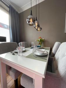 基尔Altbaucharme Deluxe mit Balkon in zentraler Lage的一间配备有白色桌椅的用餐室