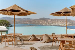 阿吉亚艾里尼帕罗Mythic Paros , Adults Only的一个带桌椅和遮阳伞的海滩