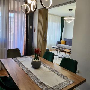 普里什蒂纳Shpetim's Apartment的一个带绿色椅子的餐桌和一间客厅