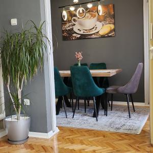 普里什蒂纳Shpetim's Apartment的一间带桌子和绿色椅子的用餐室