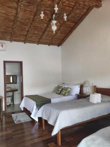 蒂拉登特斯Pedacinho do céu的一间卧室设有两张床和木制天花板