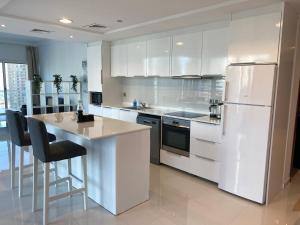 迪拜One bedroom apartment with pool & gym near Marina的厨房配有白色橱柜和白色冰箱。
