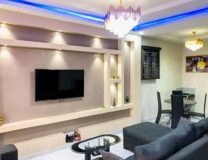 伊凯贾Crayford Homes的客厅配有沙发和墙上的电视