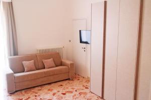 奥里亚Suite Chiara的客厅配有棕色沙发和电视