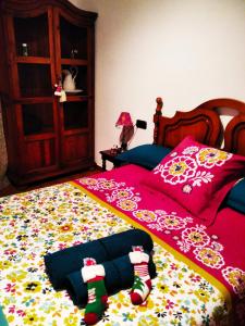 AixovallCal Jan的一间卧室配有一张带红色床罩和袜子的床