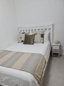 开普敦Cozy 2 bedroom APT - Near Kenilworth Racecourse的一张带枕头和白色的大白色床