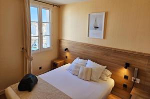 圣马丹德雷海港酒店的卧室配有带白色枕头的床和窗户。