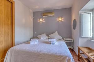 卡武埃鲁Casa Perola -ocean view cottage的卧室配有白色的床和2条毛巾