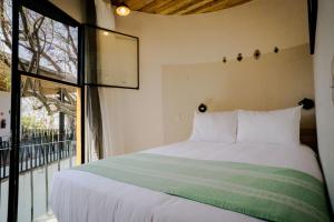 瓦哈卡市Hotel con Corazón的一间卧室设有一张床和一个大窗户
