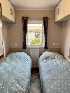 WesterlandChalet direct aan Waddenzee的小型客房 - 带2张床和窗户