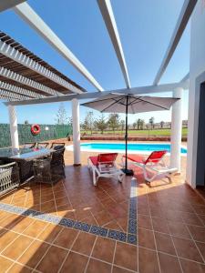 卡勒达德福斯特Villa Eva - New to the market, fully refurbished licensed villa - private pool的一个带遮阳伞和椅子的庭院和一个游泳池