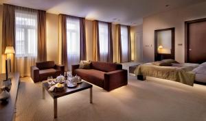 布拉迪斯拉发Roset Hotel & Residence的酒店客房,配有床、沙发和椅子
