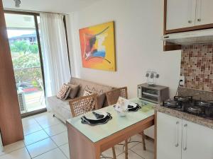 巴西利亚Life Resort Flat - Torre F - Beira do lago的厨房以及带桌子和沙发的客厅。