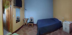 San Lucas TolimánHotel y Restaurante Tzutujil的一间卧室配有一张床、梳妆台和电视。