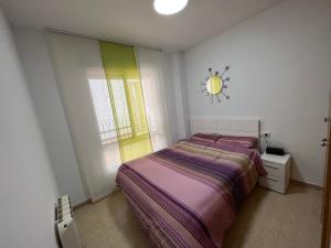 卡耐特蒂贝兰格Apartamento Canet d’en Berenguer的卧室配有一张床,墙上挂着一个钟