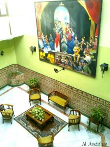 赫雷斯-德拉弗龙特拉阿尔安达卢斯赫雷斯酒店的墙上有画作的房间和桌子