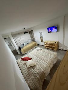 罗萨里奥Departamento monoambiente Barrio Martin的酒店客房设有两张床和电视。