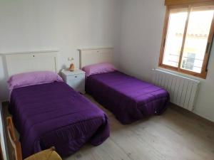 比拉法梅斯Vivienda turística Ca Lola的紫色床单的客房内的两张床