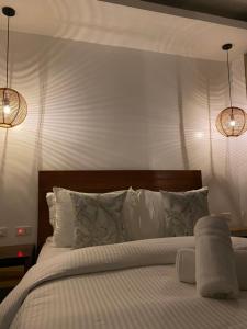 卢纳将军城Woody's Place Siargao的一间卧室配有一张带白色床单和两盏灯的床。