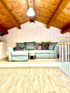 科森扎GG HOME的客厅设有绿色沙发和木制天花板