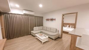 Ban Na KhamNakara Hotel, Ubon Ratchathani的带沙发和镜子的客厅
