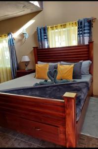 拉纳韦贝Cambridge mi casa ur casa with pool and beach access的一间卧室配有一张带黄色枕头的大型木制床。
