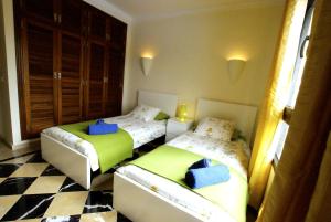 普拉亚布兰卡亚历杭德罗别墅度假屋的一间卧室设有两张床,铺有一个 ⁇ 板地板