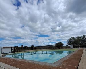 雷根古什-迪蒙萨拉什HERDADE DO CORVAL的一座背景为阴天的游泳池