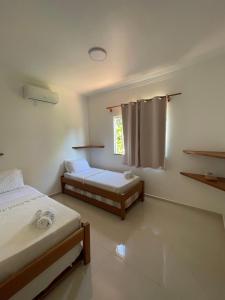 塞古罗港P&M'S Porto Seguro Taperapuan的一间卧室设有两张床和窗户。