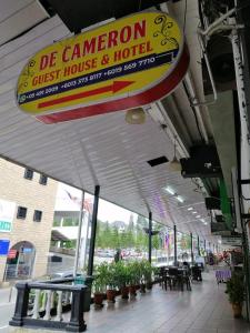 丹那拉打De Cameron Guest House的一间标有读取骆驼旅馆和酒店的标志的餐厅