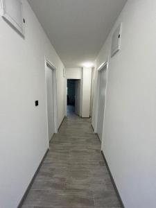 大戈里察Rooms Jelak的一条空的走廊,有白色的墙壁和瓷砖地板
