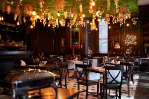 皮亚特拉-尼亚姆茨中央广场酒店 的餐厅设有桌椅和吊灯。