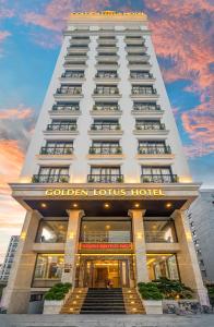 岘港Golden Lotus Hotel Da Nang的一座高大的白色建筑,上面有标志