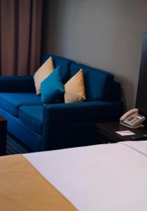马斯喀特Best Western Premier Muscat的一张蓝色的沙发,坐在一个电话房间里